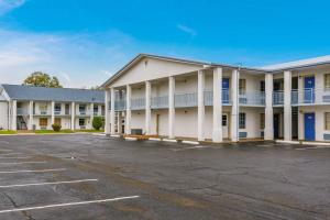 a large white building with a parking lot at Motel 6-Alexandria, LA - South in Alexandria