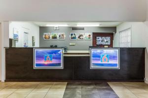 una zona de espera en un hospital con tres televisores en Studio 6-Alexandria, LA, en Alexandria