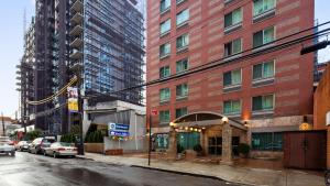 un edificio en una calle con coches aparcados delante en Best Western Queens Court en Queens