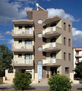 un edificio con balcones en un lateral en Niriides Studios and Apartments, en Paralia Katerinis