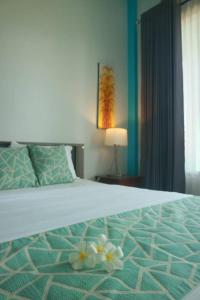 sypialnia z łóżkiem z kwiatami w obiekcie Villa Rembulan w Gili Trawangan