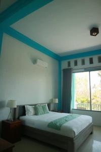 a bedroom with a large bed and a window at Villa Rembulan in Gili Trawangan