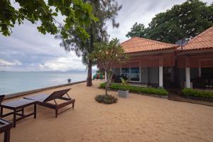 a building on the beach next to the ocean at Maenam Villa Hotel in Mae Nam