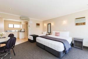 パーマストンノースにあるComfort Inn Kauri Courtのベッド2台とキッチンが備わるホテルルームです。