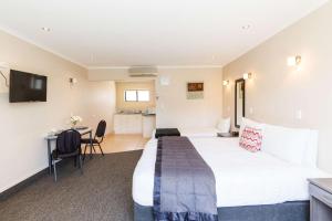 um quarto de hotel com uma cama e uma secretária em Comfort Inn Kauri Court em Palmerston North