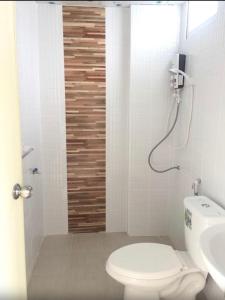 a white bathroom with a toilet and a sink at SKF Apartment in Sakon Nakhon