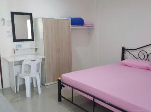 a bedroom with a bed and a desk and a chair at SKF Apartment in Sakon Nakhon