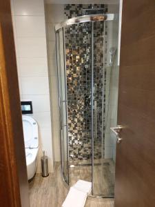 a bathroom with a glass shower with a toilet at Apartmani Astoria 1 in Jahorina