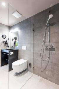 a bathroom with a toilet and a glass shower at RiKu HOTEL Pfullendorf in Pfullendorf