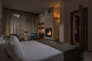 Habitación de hotel con cama y chimenea en Boutique Hotel Uniqato en Bansko