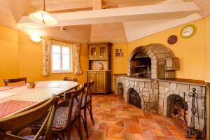 a kitchen with a table and a stone fireplace at Roubenka Anna in Dolní Polubný
