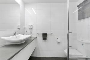 a white bathroom with a sink and a toilet at Waves on Banyan formerly Comfort Inn International in Warrnambool +56 photos
