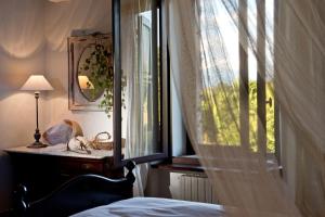 ein Schlafzimmer mit einem Fenster, einem Bett und einem Spiegel in der Unterkunft Agriturismo Tra Le Vigne in Buttrio