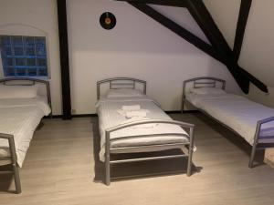 two twin beds in a room with wooden floors at Zehntscheune Walzbachtal (Wössingen) in Wössingen