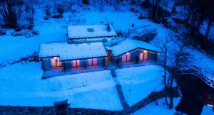 uma vista aérea de uma casa coberta de neve à noite em Lo Tzeno em Fenis