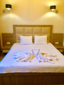 a bed with three towels in the shape of hearts at Iveria in Batumi