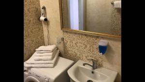 a bathroom with a sink and a toilet and a mirror at Light Apartments in Chernihiv