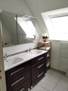 a bathroom with two sinks and a large mirror at la frégate blanche in Concarneau