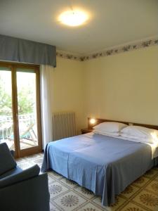 a bedroom with a bed and a chair and a window at Residence i Morelli in Pietra Ligure