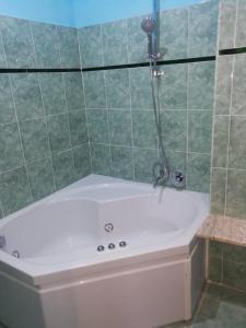 a bath tub in a green tiled bathroom at Le colline in Capena