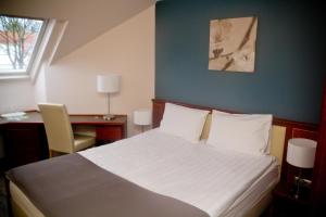 a bedroom with a bed and a desk and a window at Old Lake Golf Hotel in Tata +11 photos