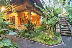 una casa con un montón de plantas en el patio en Hibiscus Cottages, en Ubud
