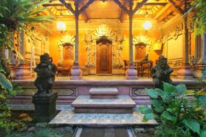 a room with statues in the middle of a building at Hibiscus Cottages in Ubud