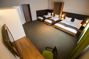 
a hotel room with a bed, desk, chair, and nightstand at RiKu HOTEL Neu-Ulm in Ulm
