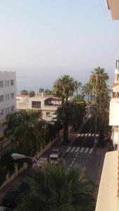 a view of a street with palm trees and the ocean at Herradura Tropical in La Herradura