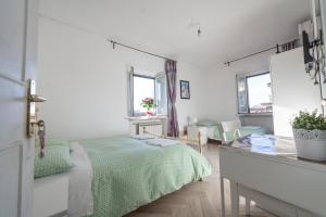 ein weißes Schlafzimmer mit einem Bett und einem Schreibtisch in der Unterkunft Meile House in Rom