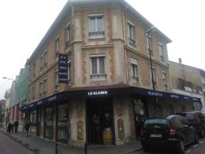 ein Gebäude auf einer Straße mit vor der Tür geparkt in der Unterkunft Le Kleber in Montreuil