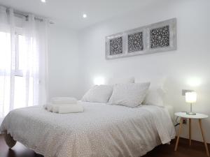 Un dormitorio blanco con una cama blanca y una ventana en Aries Flat, en Benalmádena