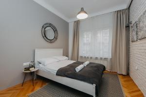 a bedroom with a bed with a mirror and a window at ShortStayPoland Marszałkowska (B28) in Warsaw