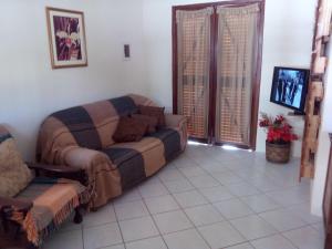 sala de estar con sofá y TV en Casas na Praia de Bombas - Bombinhas, en Bombinhas