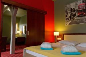 Old Lake Golf Hotel في تاتا: غرفة نوم بسرير بجدار احمر
