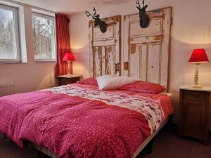 Schlafzimmer mit einem großen Bett mit einem Kopfteil aus Holz in der Unterkunft Waldgasthaus & Pension Teichhaus in Holzhau