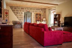 a red couch in a living room with a stone wall at Chalet Vecchio Rifugio - Monte Amiata in Castel del Piano