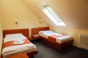 a bedroom with two beds and a skylight at Lipa Hotel és Étterem in Szentgotthárd +19 photos