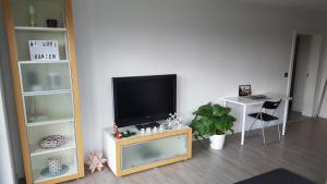 a living room with a flat screen tv on a stand at Haus am Prekkesee in Xanten