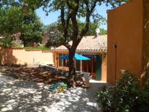 una casa con un árbol y un paraguas azul en Villa Célestine, en Roussillon