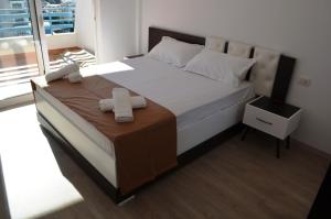 1 dormitorio con 1 cama con 2 toallas en Celin Apartment, en Sarandë