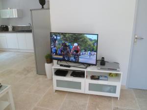 a television sitting on a white entertainment center at Villa Célestine in Roussillon