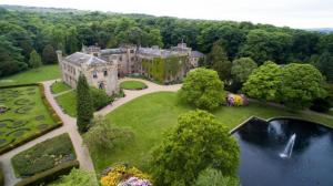 una vista aérea de una antigua mansión con un estanque en Travis House One, en Burnley