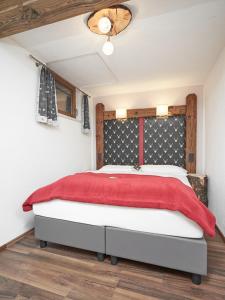 Apartment Ötztal في Tumpen: غرفة نوم بسرير كبير مع بطانية حمراء
