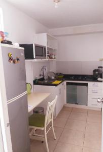 uma pequena cozinha com um frigorífico e uma mesa em Urban House em Lima
