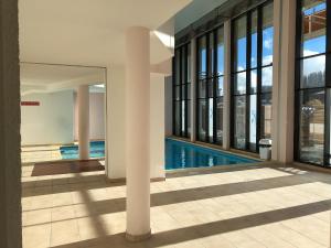 a swimming pool in a building with windows at Appartement Valberg in Valberg