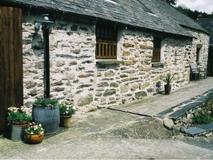 an old stone building with a porch and a street light at Plasglasgwm in Betws-y-coed