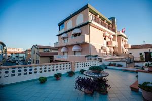 un edificio con piante in vaso di fronte ad esso di Hotel Sileoni a Marina di Cecina