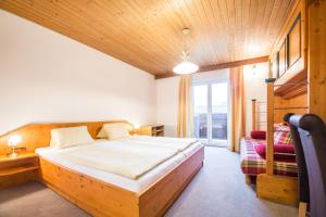 una camera con un grande letto e una finestra di Haus Alpenland a Wagrain