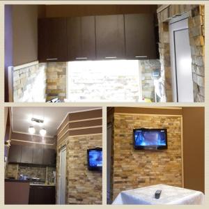 uma cozinha com uma parede de pedra com uma televisão em Guest Rooms Exotic em Pazardzhik